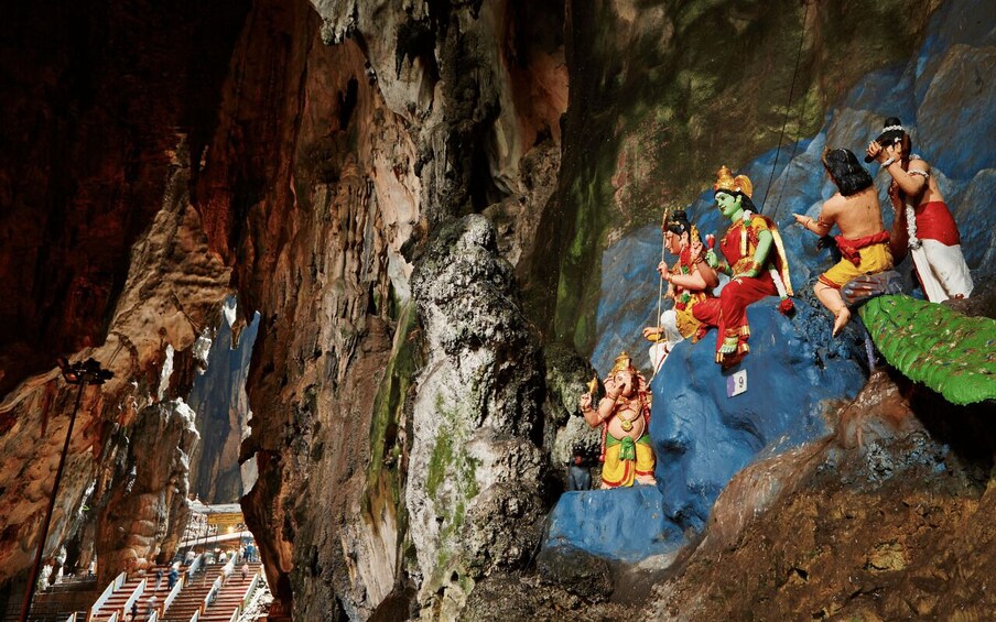A cave with rock formations and statues of deities. 5