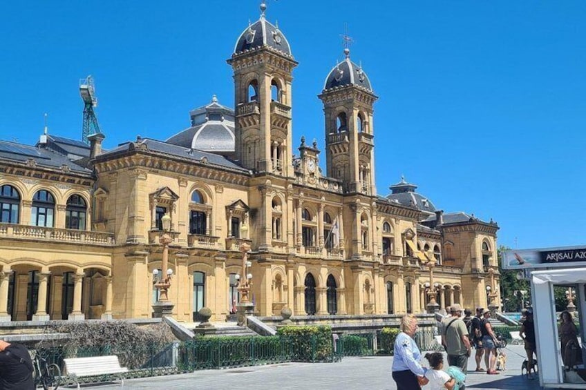 A historic building with ornate architecture, including domes and towers, and a clear blue sky. 4