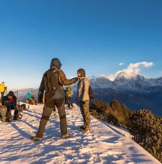 A snowy mountain peak with a clear sky and a person in the foreground. 1