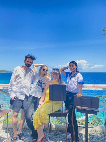 A group of people by a pool with a clear blue sky and ocean in the background. 3