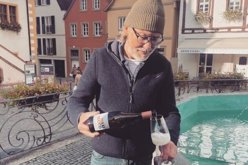 A person pouring a drink from a bottle into a glass. 2
