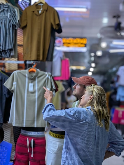 A person pointing at a clothing rack in a store. 4