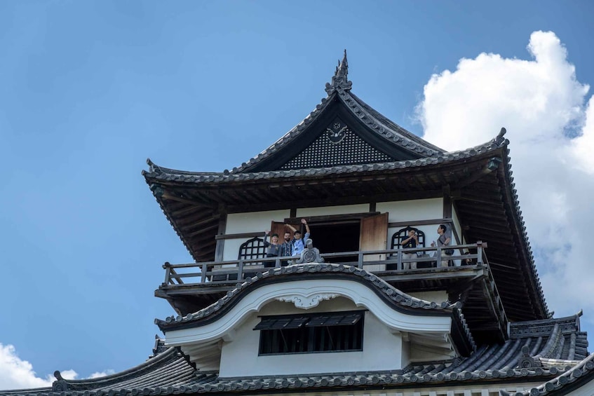 A traditional multi-tiered building with ornate roof tiles and a balcony. 1