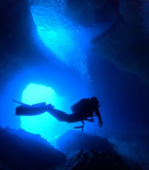 A diver in a cave with a blue light source. 1