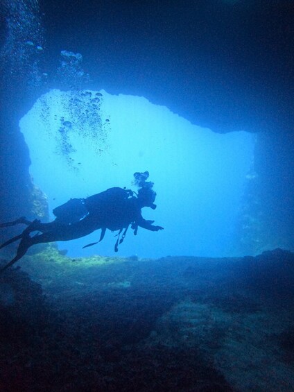 A diver in a cave with a blue light source. 5