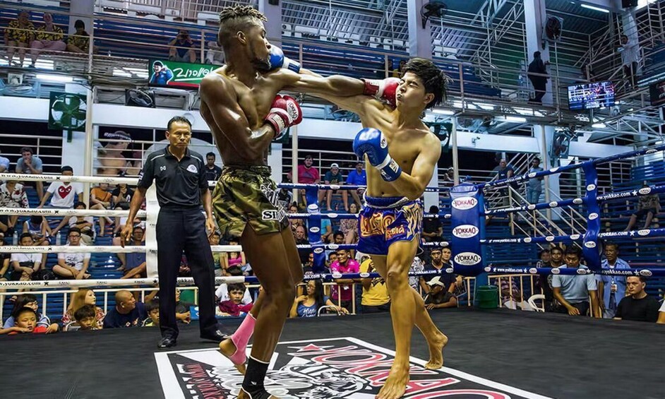 A boxing match in a ring with spectators. 1