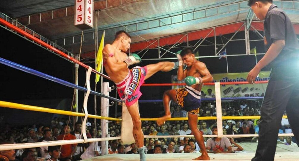 A boxing match in a ring with a crowd in the background. 5