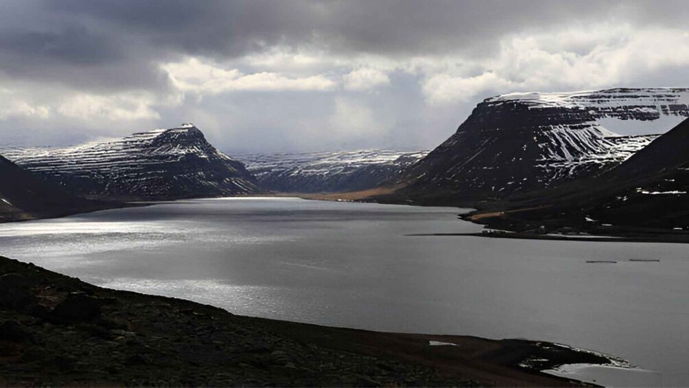 A glacier lake surrounded by snow-covered mountains. 5