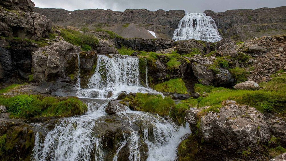 A waterfall cascading over rocks in a rugged landscape. 1