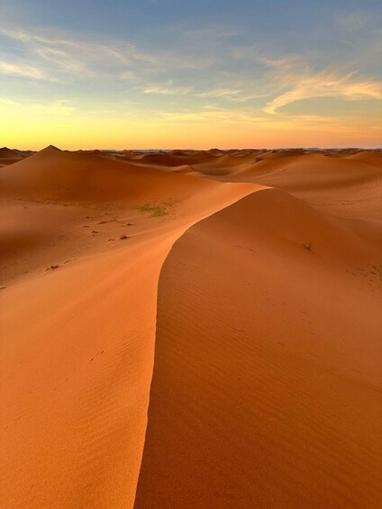 A desert landscape with sand dunes and a clear sky. 4