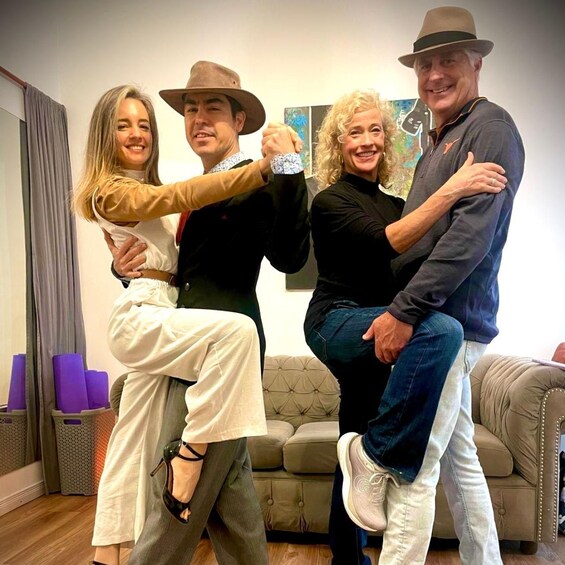A group of people in a living room with a couch and a painting on the wall. 1