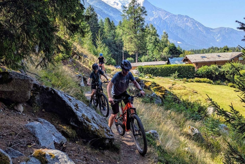 Mountain bikers on a trail with a mountain backdrop. 1