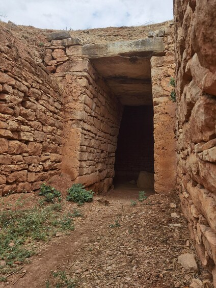 A stone structure with a narrow passageway leading into a dark interior. 5