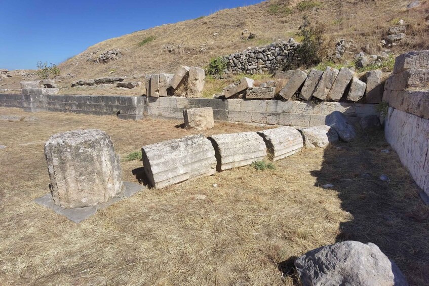 Ancient stone walls and ruins in a dry, grassy landscape. 3