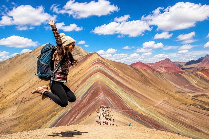 A person jumping in a colorful landscape with mountains in the background. 4