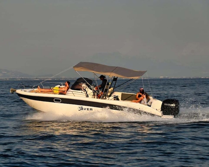 A speedboat with a canopy, named 'JAVER,' moving swiftly through the water. 4