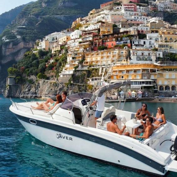A boat named JAVER on calm waters with a coastal town in the background. 1