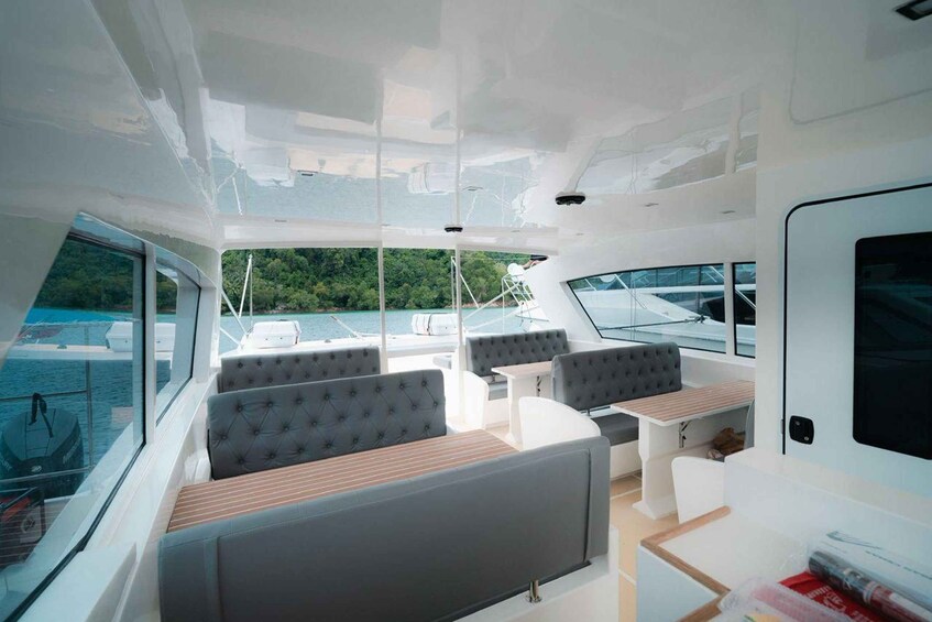A modern yacht interior with seating and a dining area. 3