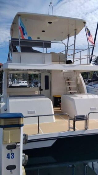 A boat deck with a covered area, railings, and an American flag. 2