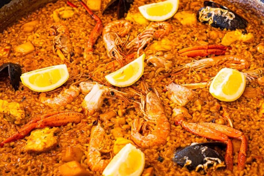 A seafood paella with shrimp, mussels, and lemon slices. 2