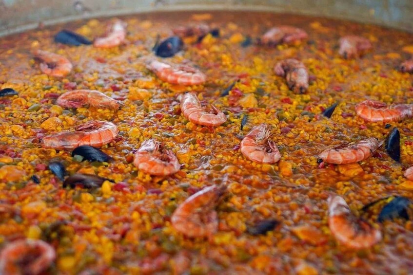 A large paella dish with shrimp and mussels. 4