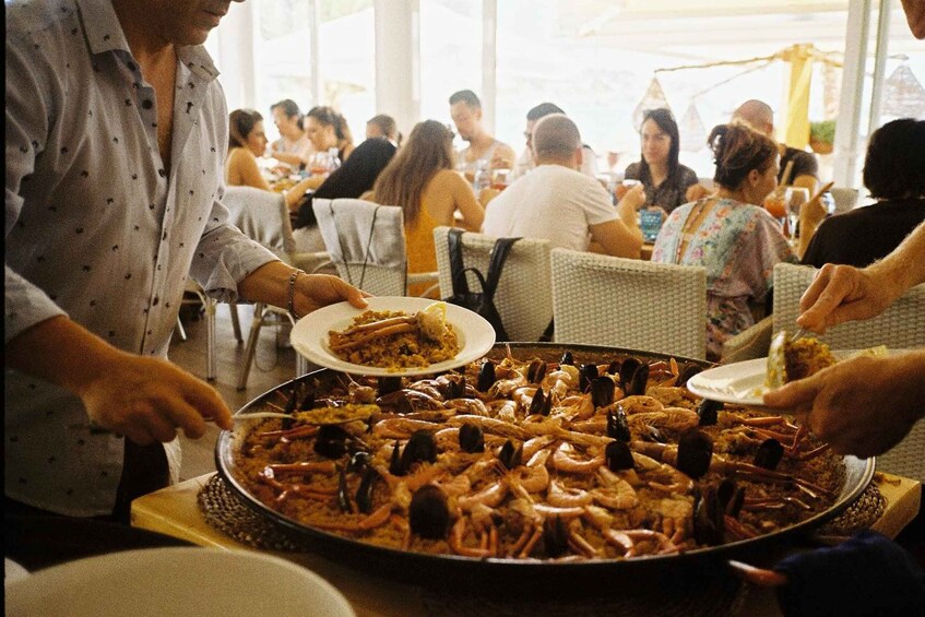 A large seafood platter with shrimp and mussels being served at a gathering. 1