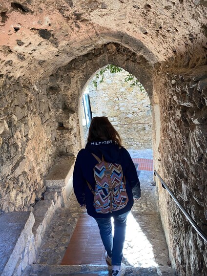 A person walking through a stone archway. 3