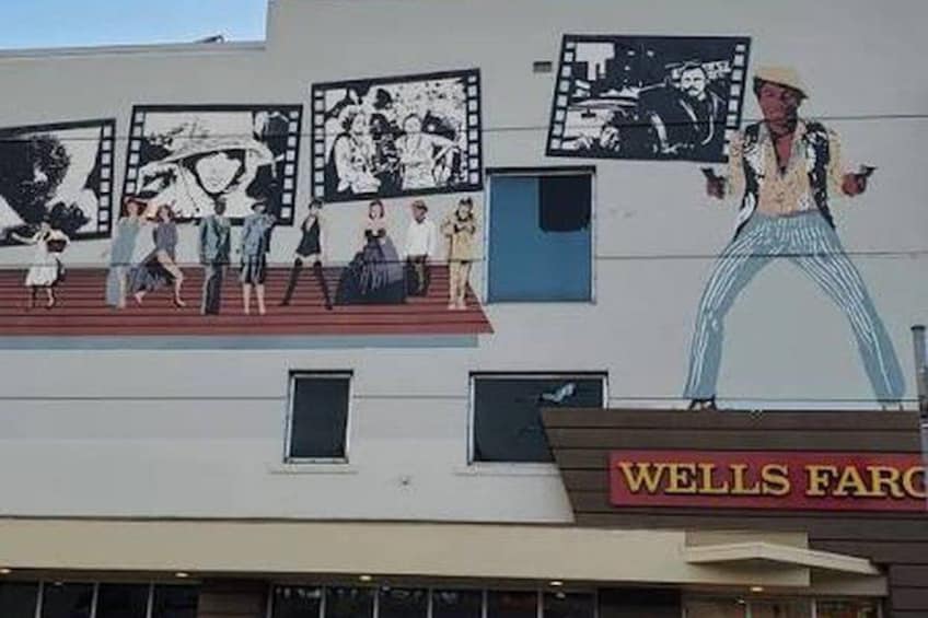 En bygning med et stort mural af mennesker og et skilt fra Wells Fargo. 2
