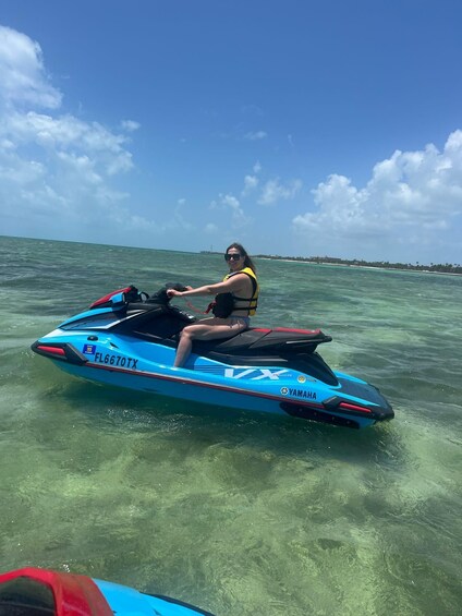 A person riding a blue Yamaha jet ski on clear turquoise water. 3
