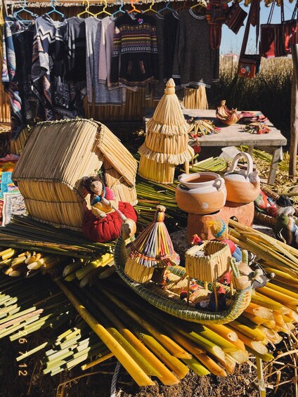 A market stall with handcrafted items, including a straw hut, pottery, and colorful textiles. 5