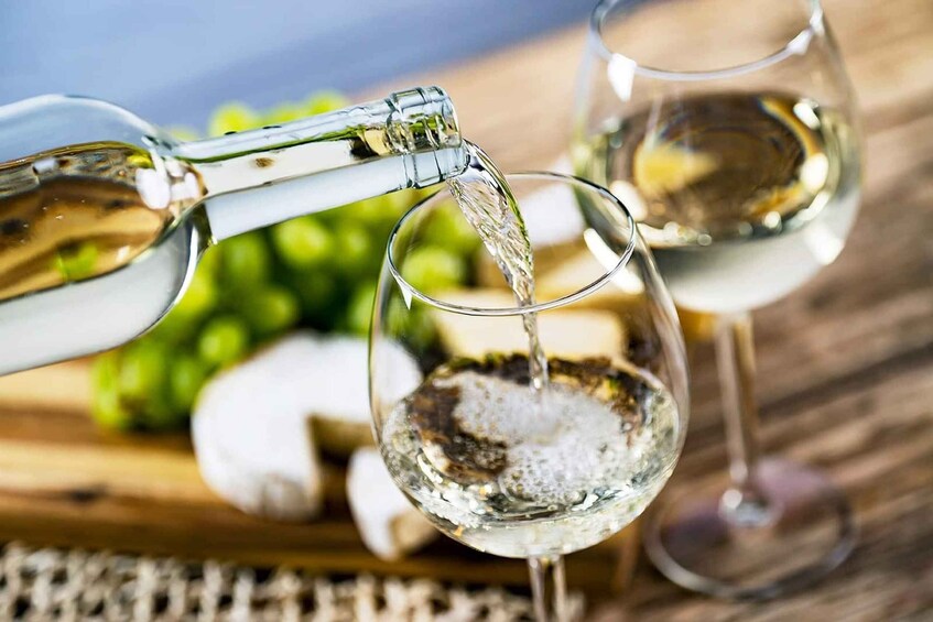 A glass being filled with a clear liquid, likely water, with a bottle pouring into it. 5