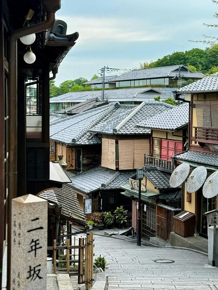A traditional Japanese courtyard with tiled roofs, wooden structures, and a stone lantern. 5
