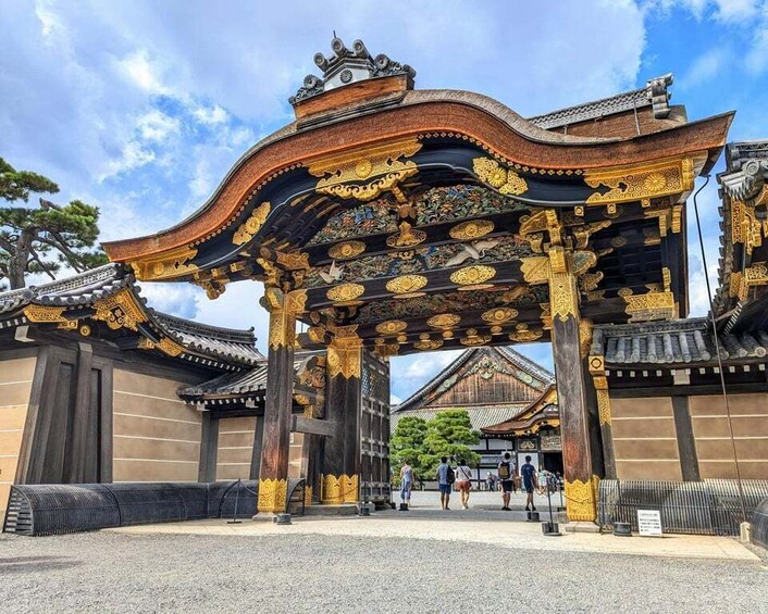A traditional Japanese gate with intricate golden decorations and a tiled roof. 2