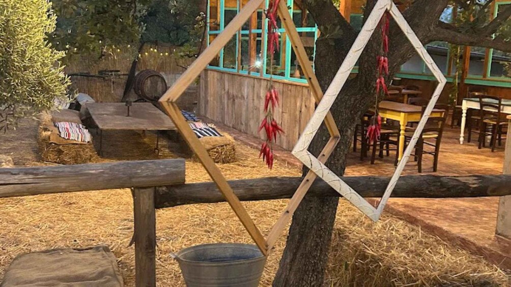 A rustic outdoor setting with wooden fences, hay bales, and a wooden structure with windows. 3