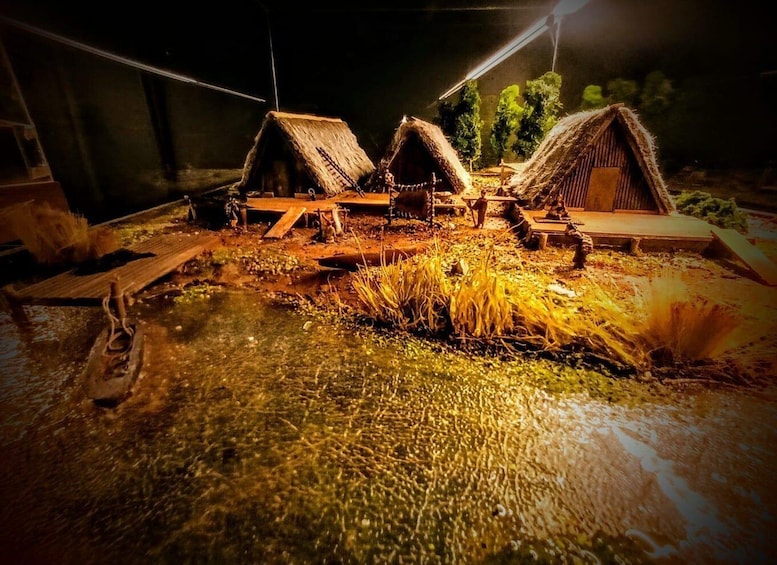 A nighttime scene with thatched-roof huts and a wooden structure, possibly a shed, in a rural setting. 3