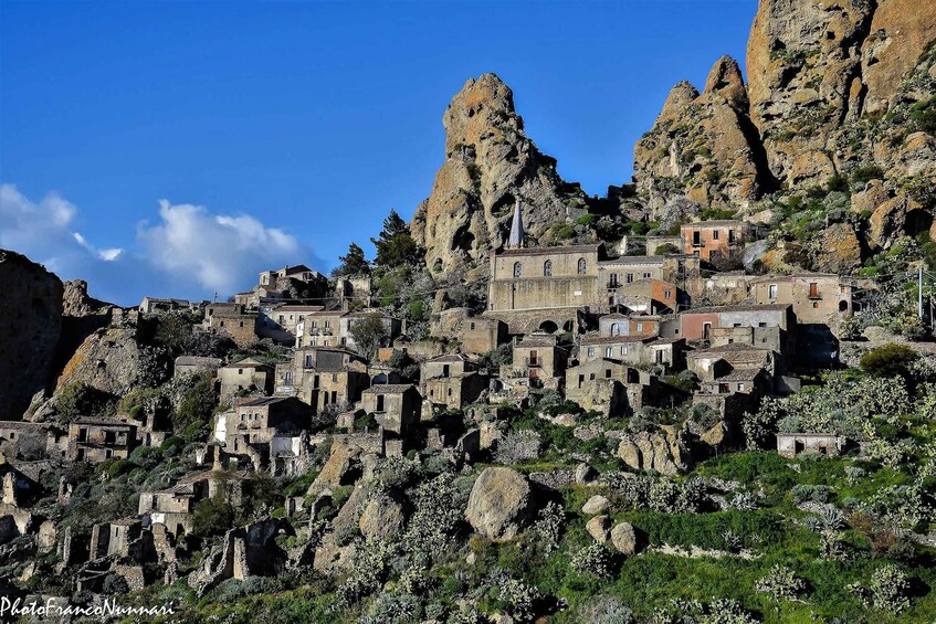 A rugged mountainous village with ancient stone buildings perched on rocky cliffs. 1