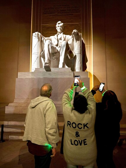 A statue of Abraham Lincoln with people taking photos. 5
