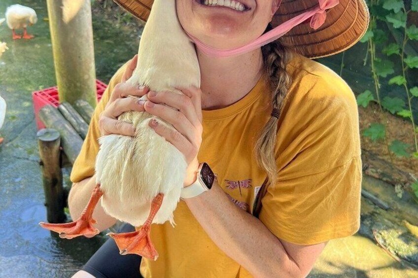 A person holding a white chicken with orange feet. 5