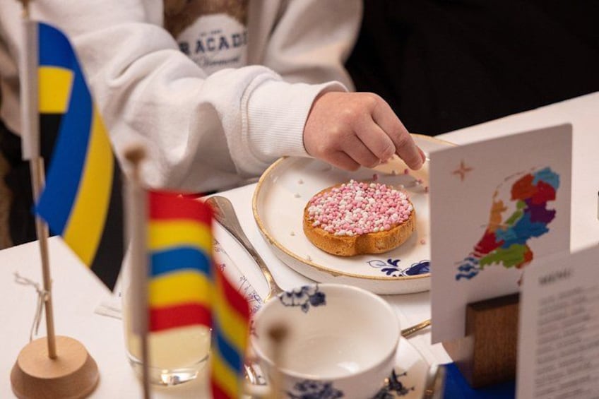 A person serving a pink and white sprinkled pastry on a plate. 4