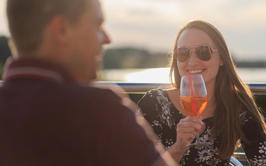 A person holding a glass of red wine. 3