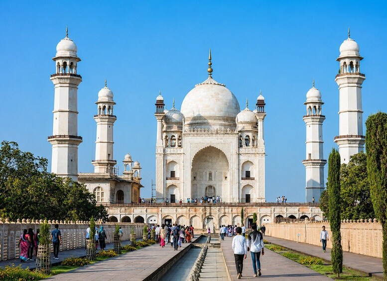 The Taj Mahal with four minarets and a large central dome, surrounded by a walkway with visitors. 1