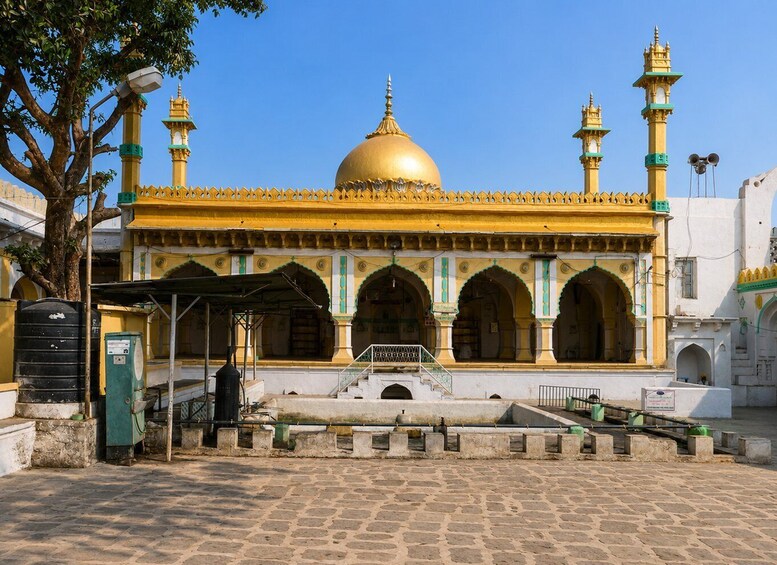 A mosque with a golden dome and minarets, set against a clear blue sky. 3