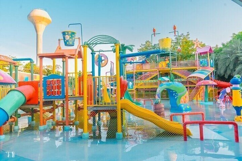 A water park with colorful play structures, slides, and a pool. 5