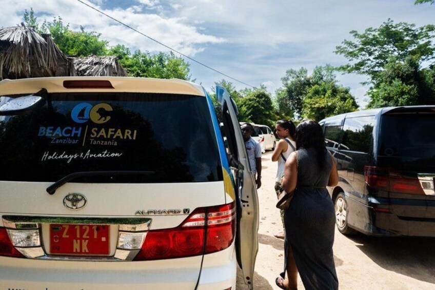 A safari vehicle with a logo and text indicating a holiday and aviation service in Zanzibar, Tanzania. 2