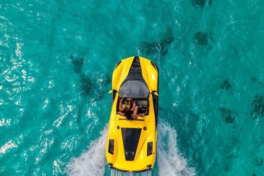 A yellow boat with two people on a turquoise sea. 1