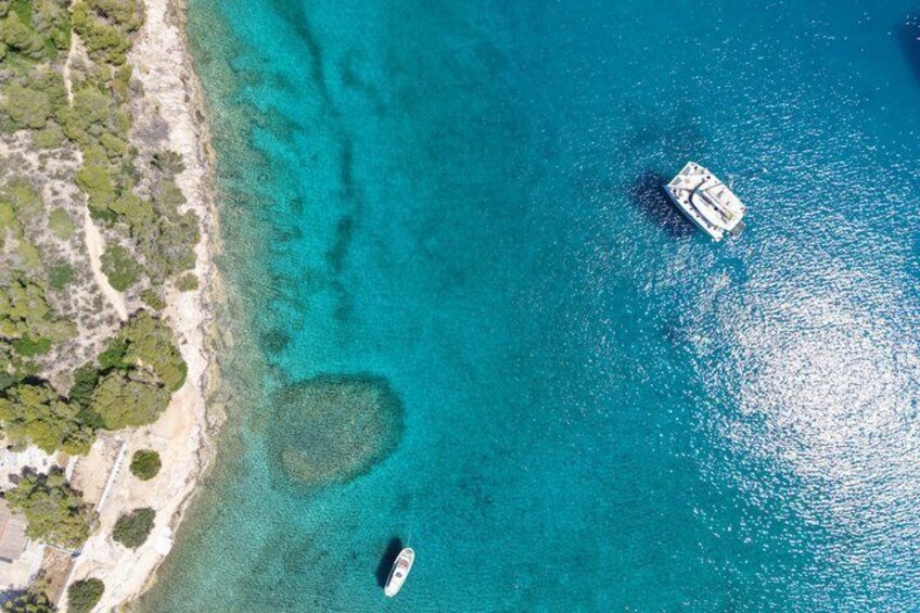 Vista aérea de una zona costera con aguas turquesas cristalinas, una playa arenosa y dos barcos. 5