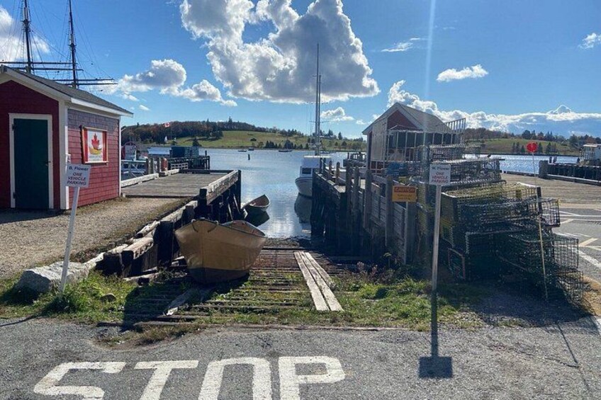 A harbor with a boat, a red building, and a dock. 3
