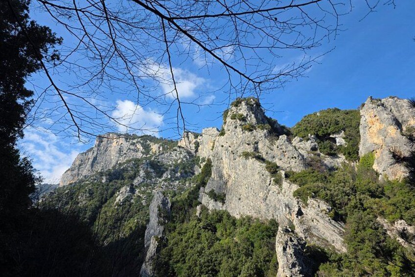 A mountainous landscape with rocky cliffs and dense greenery. 3
