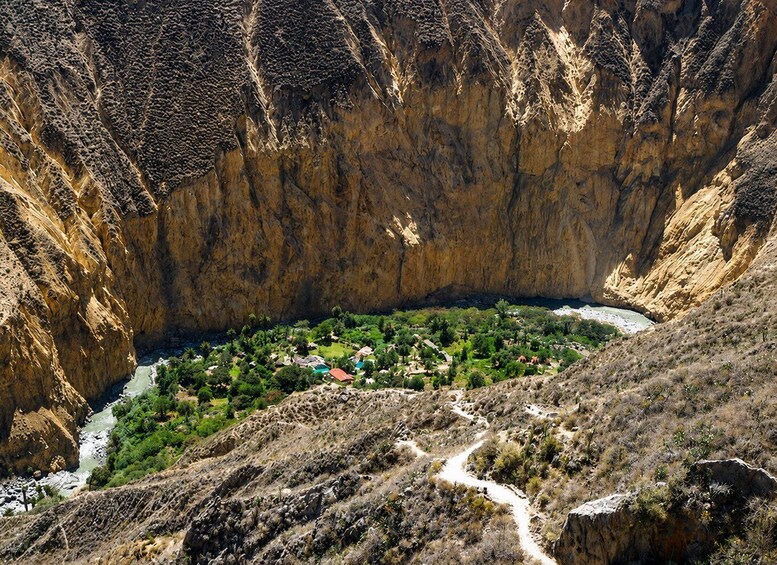 Un cañón con un río que atraviesa un pequeño pueblo rodeado de acantilados escarpados. 5