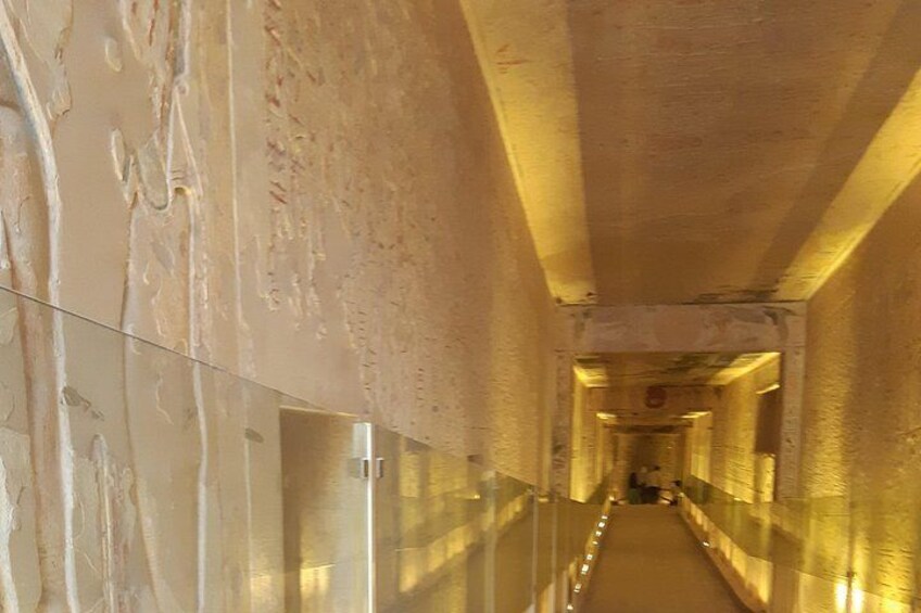 A long, narrow corridor with reflective walls and a glass barrier on one side. 2